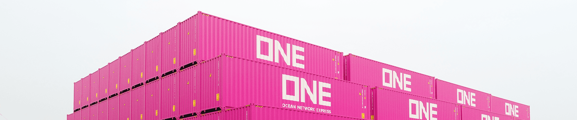A reach stacker stacking shipping containers as a vast wall at depot