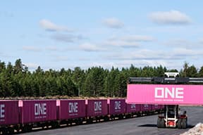 Forklift moving ONE container next to train